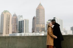 couple kissing in front of atlanta skyline